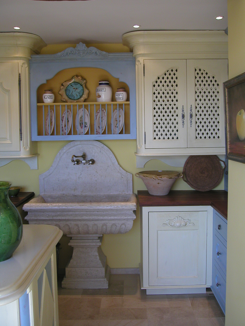 Custom designed stone sink was fabricated in Italy. Rack above it holds everyday dishes. 